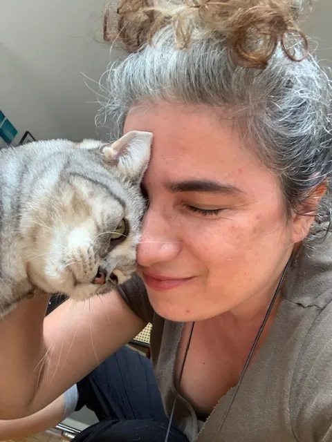Gato rajado encostando o rosto no rosto da cuidadora